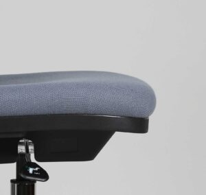 Side view, close up on an industrial chair. The edge of the chair is slightly curved, offering better support to the user’s thigh when seated.